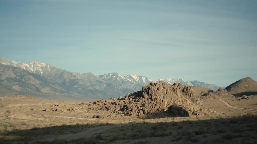 A large rock formation in an arid countryside during the day