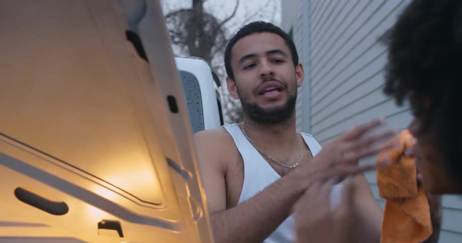 Man and woman are talking outside in the daytime by a house
