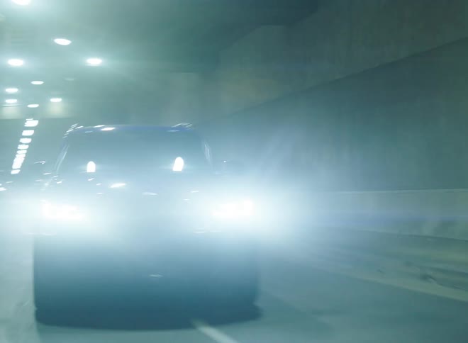 Black car accelaretes quickly in the tunnel