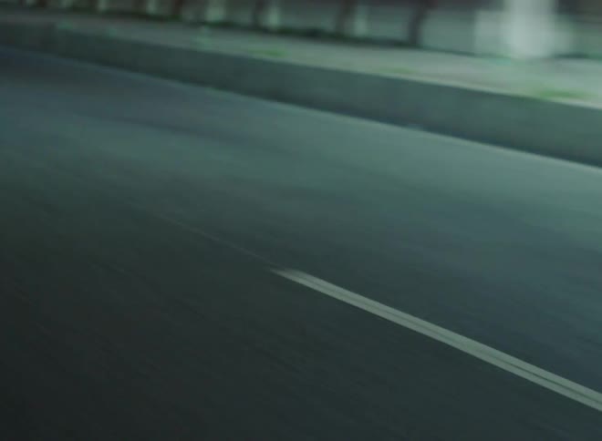 Headlights from cars are shining on the empty highway