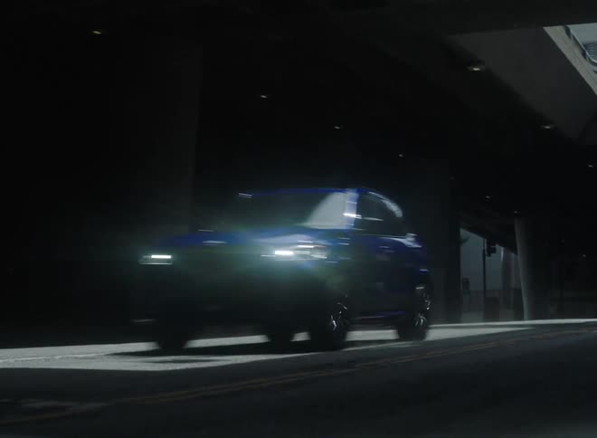 A vehicle travels along a road through a tunnel during the day
