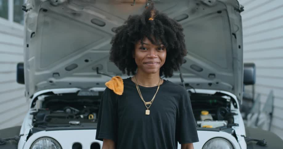 Young woman is standing in front of a vehicle