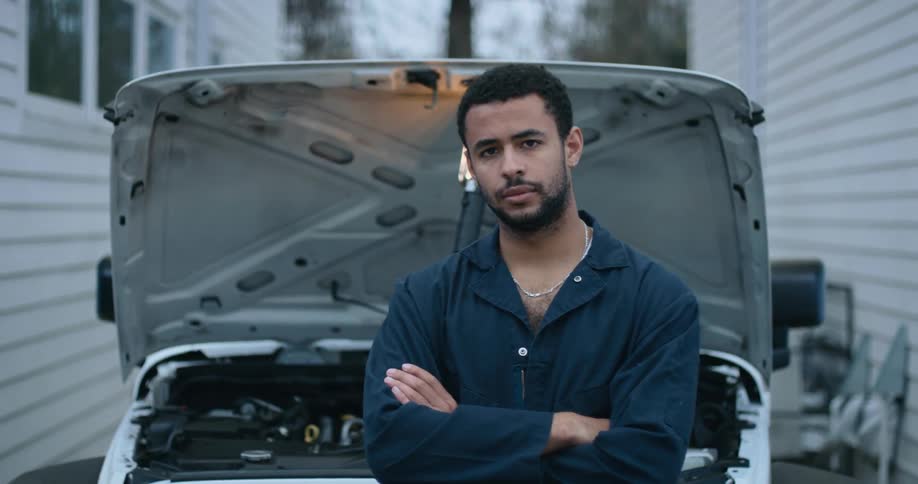 Man is sitting in front of a vehicle
