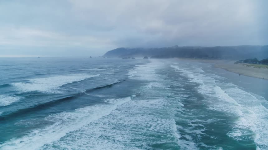 Aerial view of Pacific ocean with waves crashing into shore