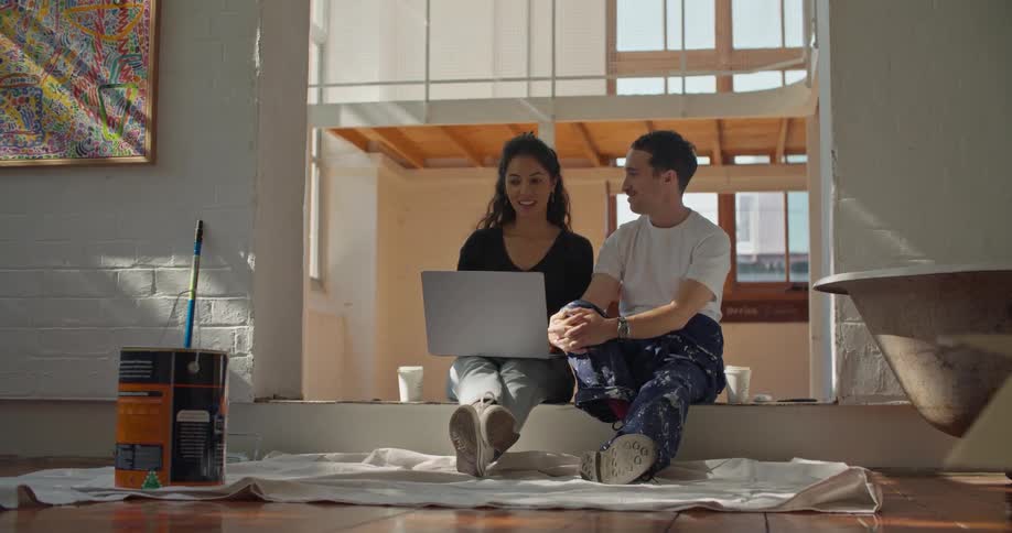 Young woman and man are sitting down on the floor in the daytime
