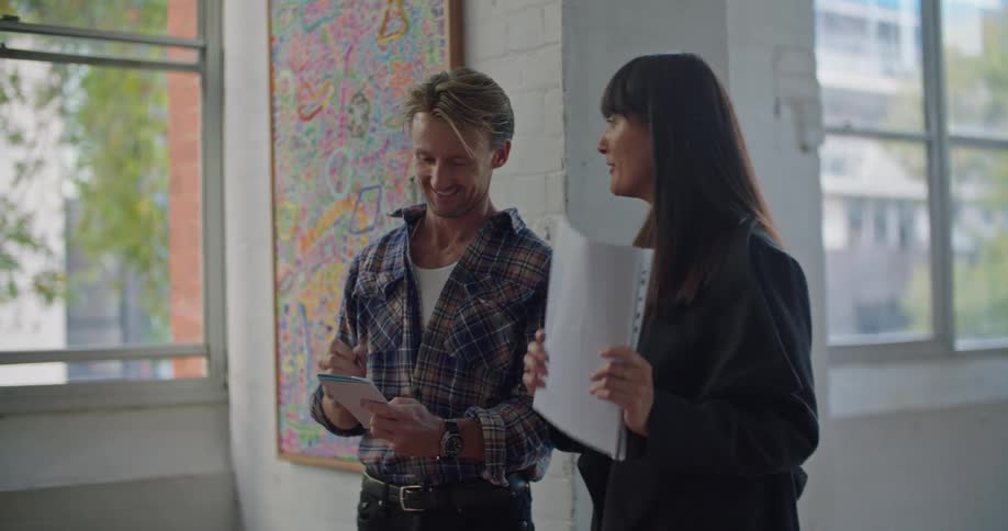 A man and woman laugh and gesture as they talk about design