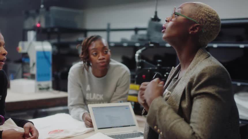 A group of coworkers in the factory talking to each other
