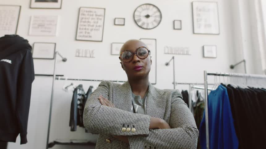 Business woman standing in front of clothes