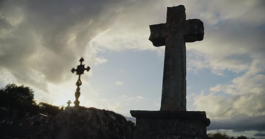Large concrete monument of a cross against a cloudy background