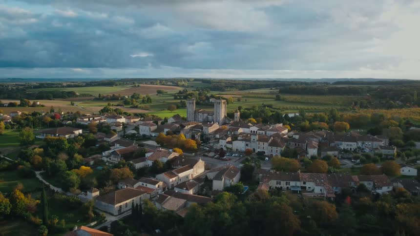 A small town in the countryside under a cloudy sky