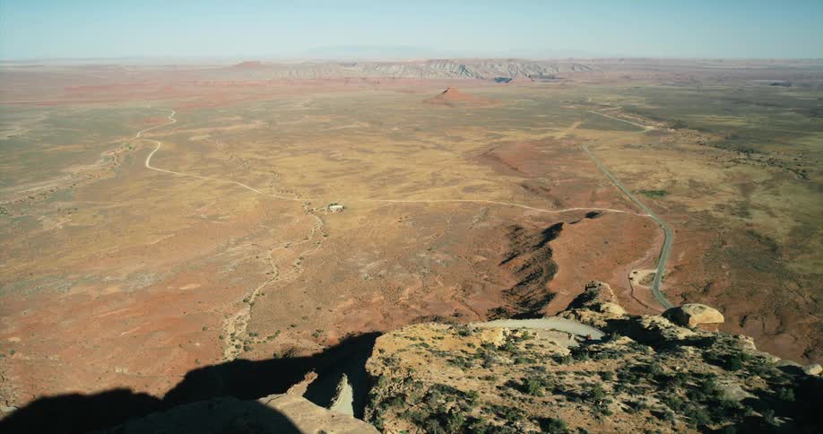Roads wind through flat area between plateaus on a hazy day