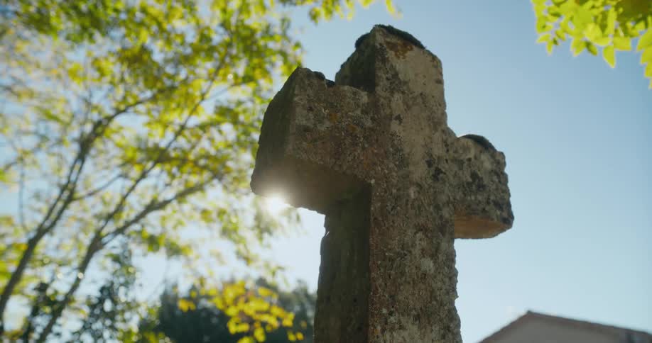 A stone cross under trees