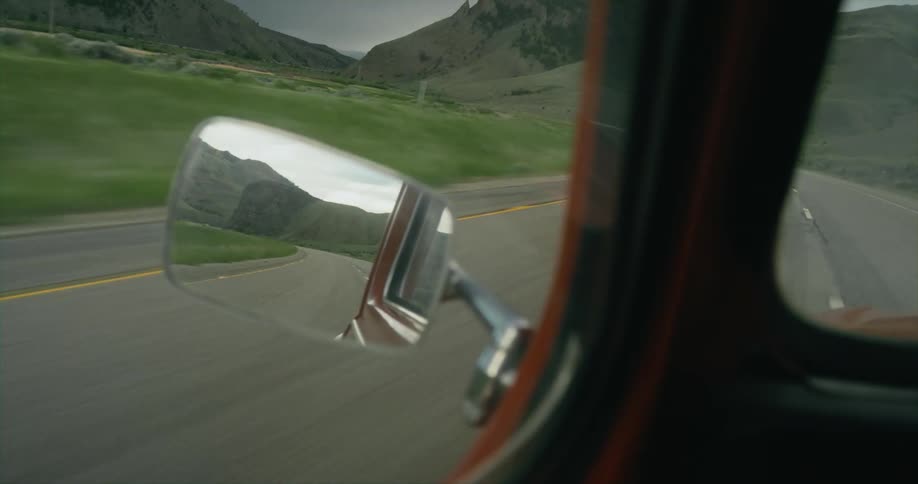 A person is driving a car in a rural area during spring
