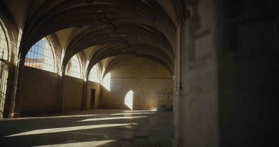 A large empty hall in a old stone building during the day