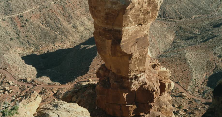 A car drives below a large rock formation