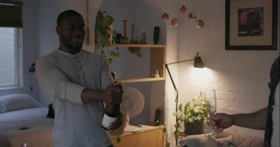 A man pops the cork on a bottle