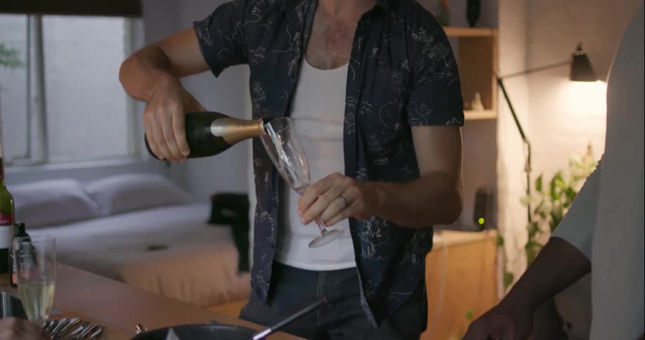 A man pours a friend a glass of champagne