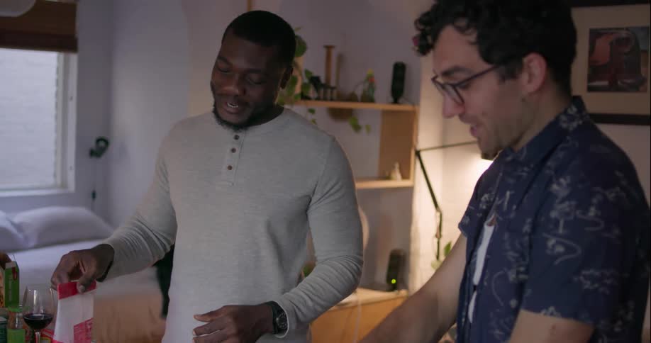 Two men converse while standing above a table