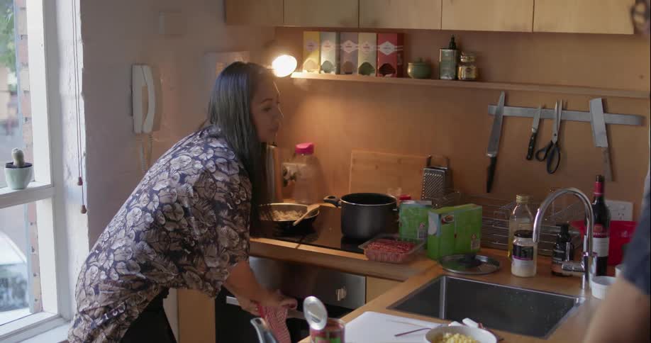 A couple talk and cook in the kitchen