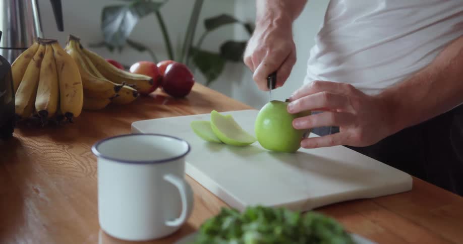 A man cuts an apple on the table