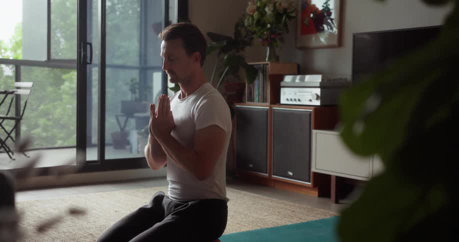 A man does yoga inside a living room