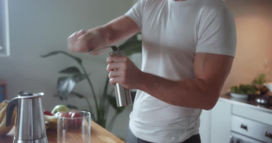 Man grinds coffee beans in the kitchen
