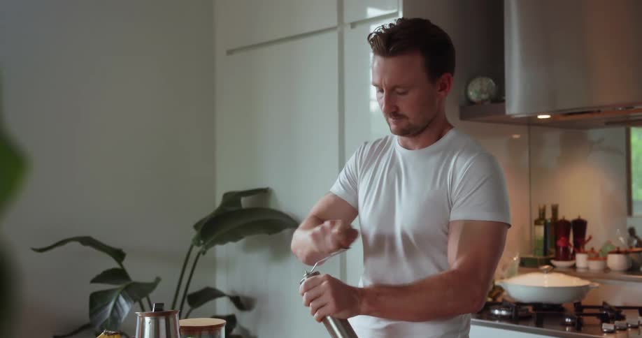 Man grinds coffee beans in the kitchen
