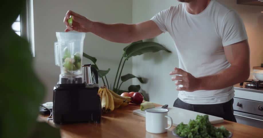 Man cuts vegetables and puts them in a blender