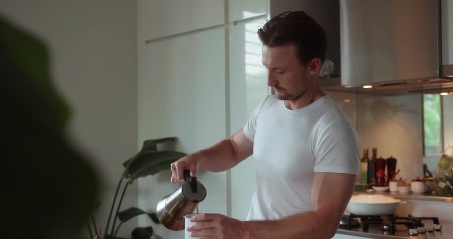 A man pours coffee into a mug