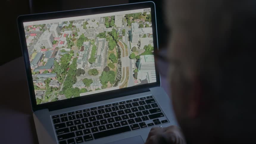 Person looks at aerial image on laptop