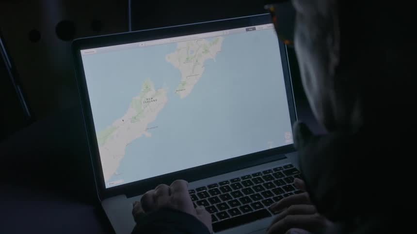 A woman looks at a topographical map on her laptop