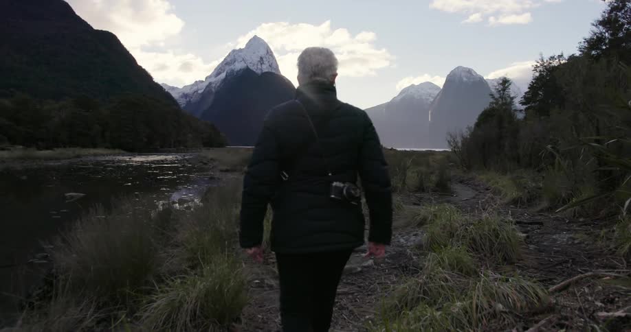A woman is hiking near mountains