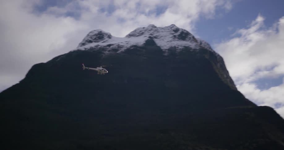 A helicopter flies over a mountain range