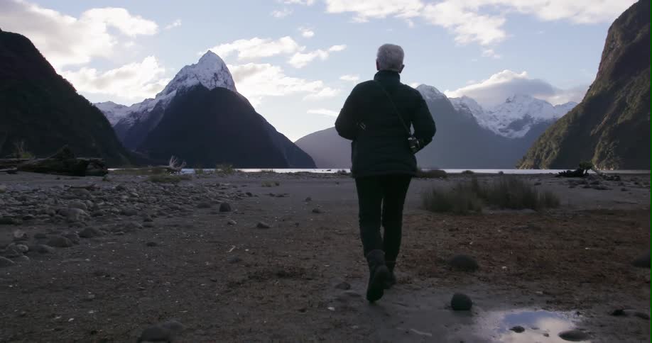 A person hikes towards the lake ahead