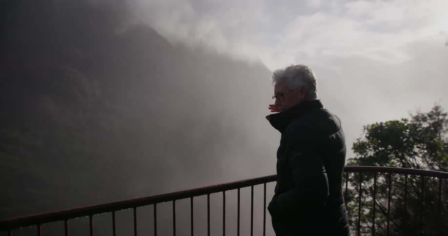 A woman looks into the canyon from a balcony