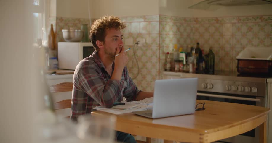 A man thinking while sitting in a kitchen