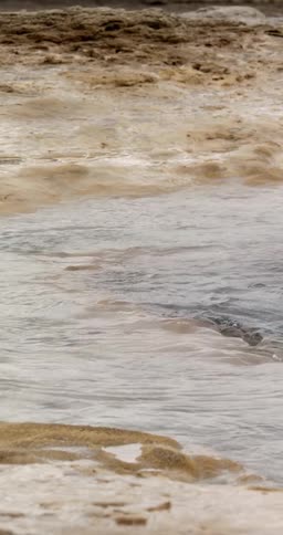 A stream running over a barren landscape during the day