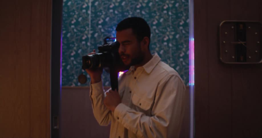Young man is video taping inside a room