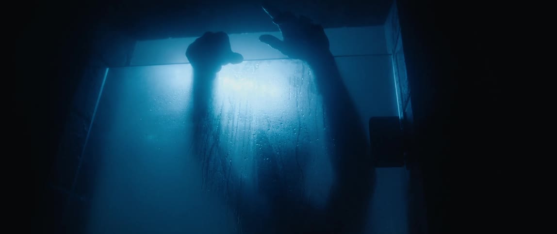 Male silhouette can be scene through condensation on shower door as he leans his hands over the door