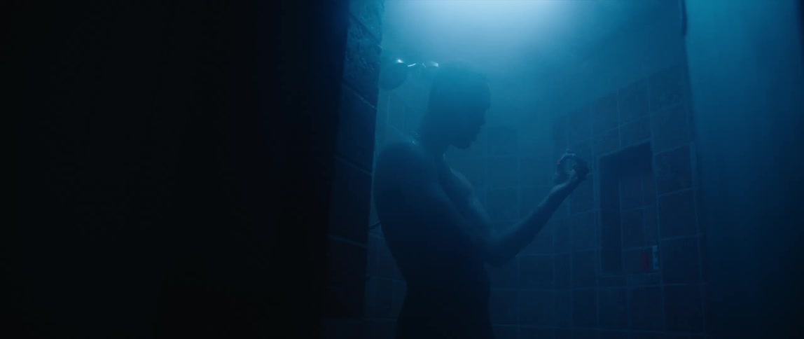 A man is showering in the dark