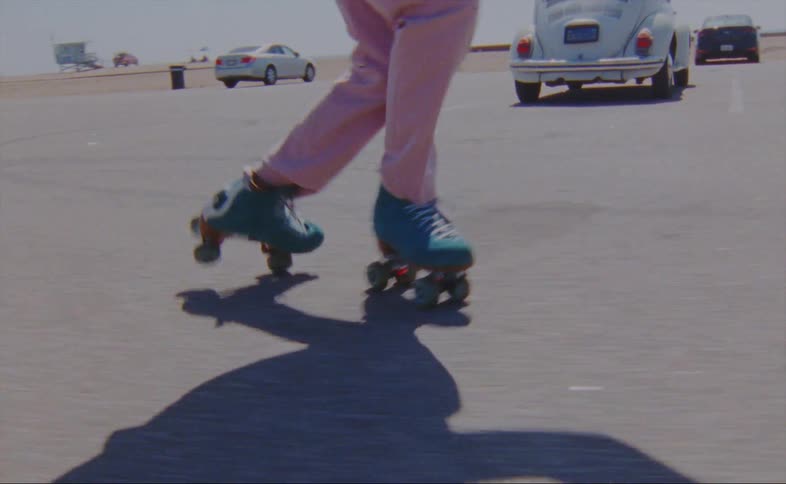 A person roller skates through a parking lot