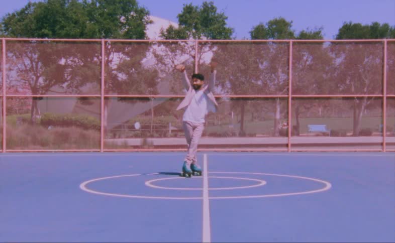 Man on turquois roller skates moves over a hard surface in the court