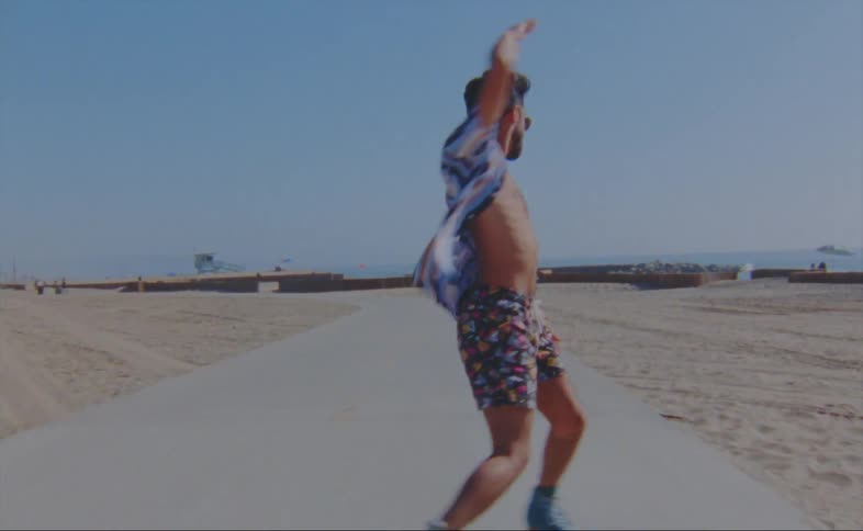 A man is skating outdoors on a sidewalk