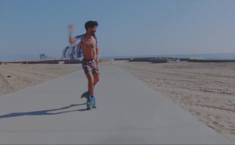 A man is skating on a sidewalk at the beach
