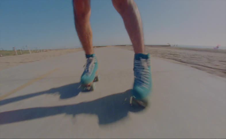A person is roller blading on a road at the beach