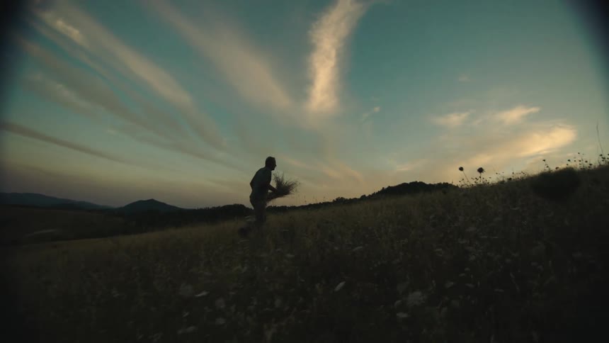 A man is carrying hay on the field