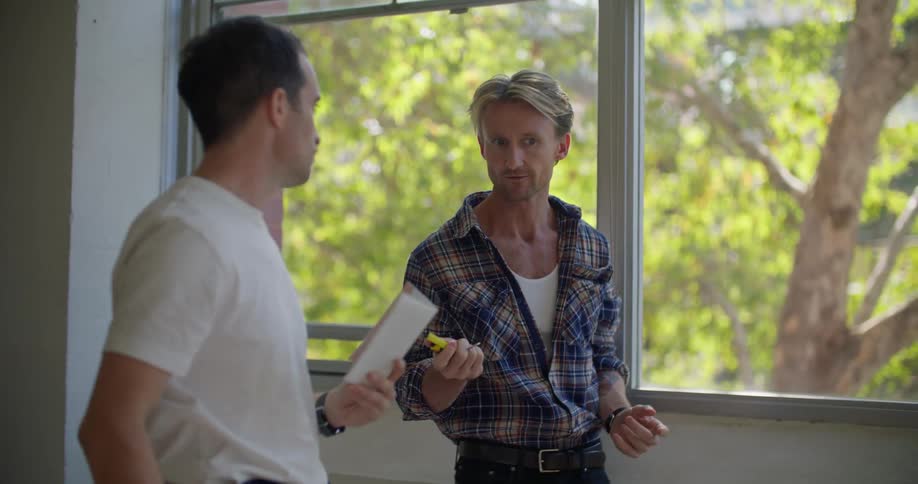 Contractors measure a large window and take notes