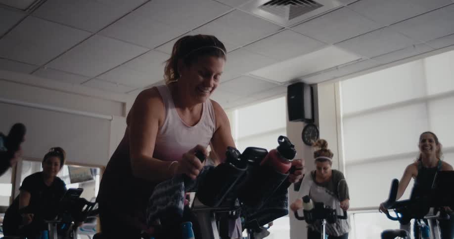 Women work out and ride exercise bikes in the gym