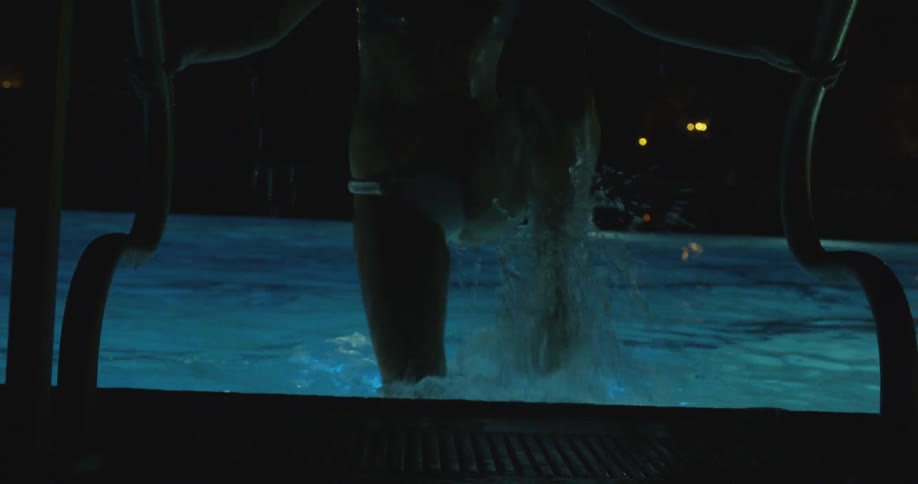 A woman gets out of a pool