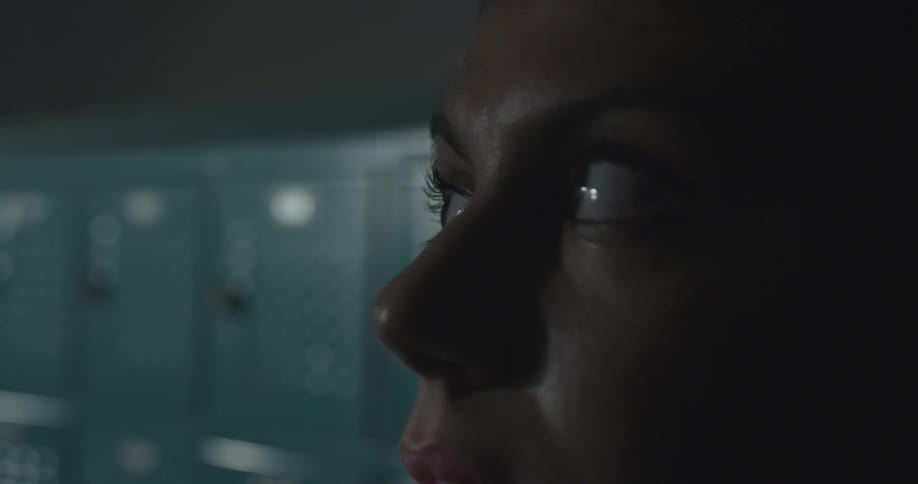 A woman is looking to the side in a locker room